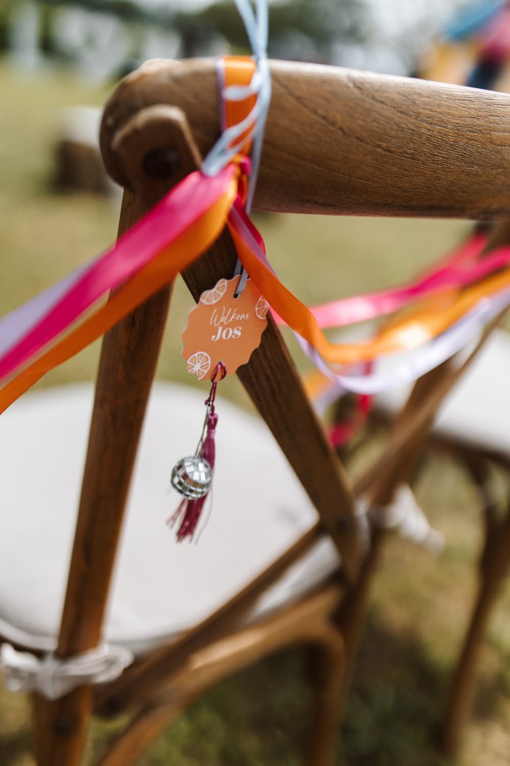 Stoel versierd met roze en oranje linten